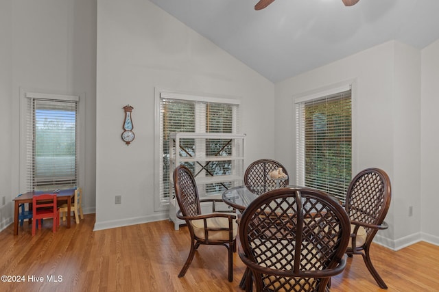 dining room featuring ceiling fan, a healthy amount of sunlight, high vaulted ceiling, and light hardwood / wood-style flooring