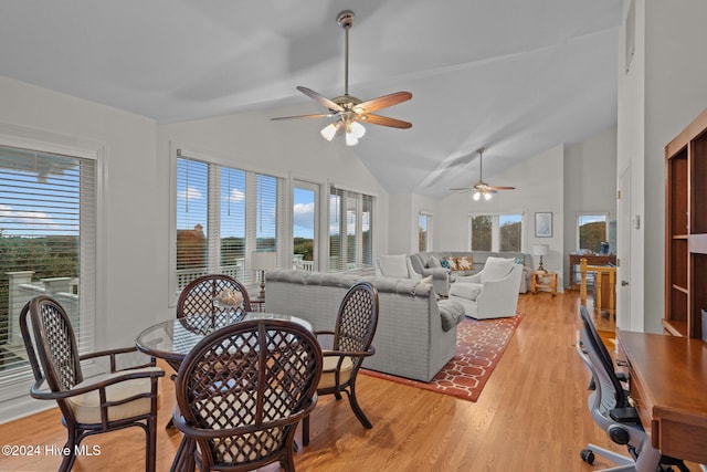 living room featuring a healthy amount of sunlight, light hardwood / wood-style floors, ceiling fan, and lofted ceiling