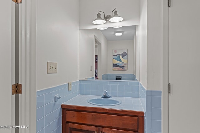 bathroom featuring vanity and tile walls