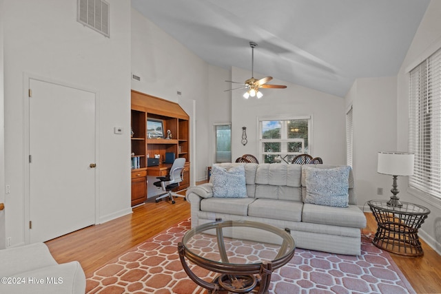 living room with hardwood / wood-style flooring, high vaulted ceiling, and ceiling fan