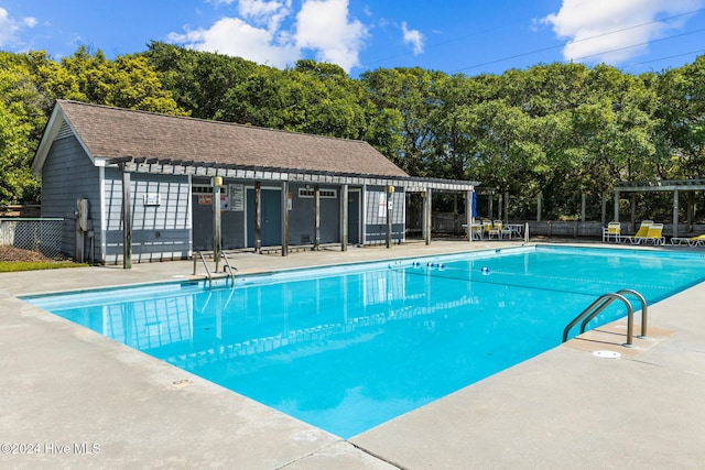 view of swimming pool featuring a patio area and an outdoor structure