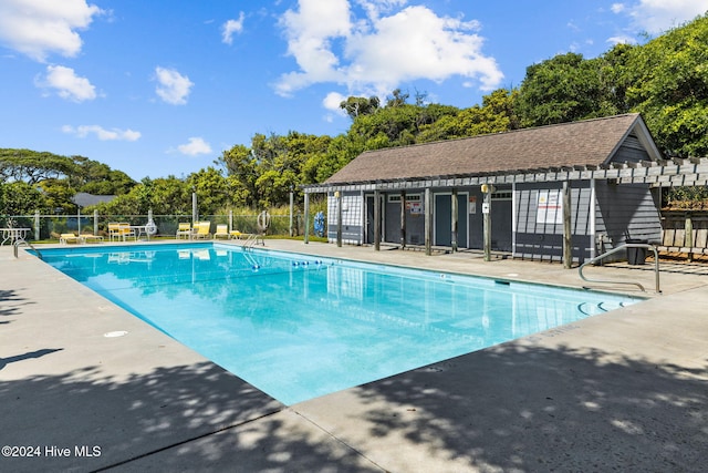 view of swimming pool with an outbuilding and a patio