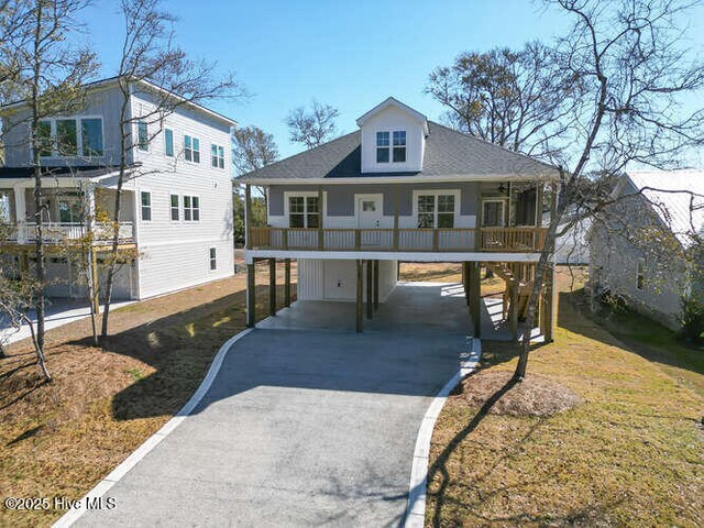 exterior space with stairs, a carport, and driveway