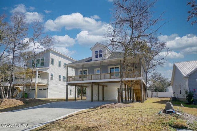 view of front of home with a front lawn, a porch, concrete driveway, a carport, and stairs