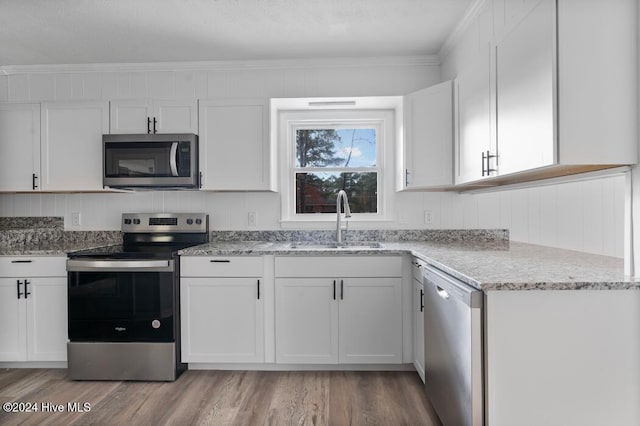 kitchen with white cabinets, light wood-type flooring, stainless steel appliances, and sink