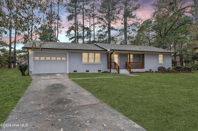 ranch-style house featuring a garage and a yard