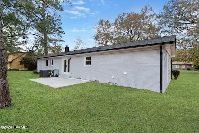 rear view of house featuring a lawn, a patio area, and central air condition unit