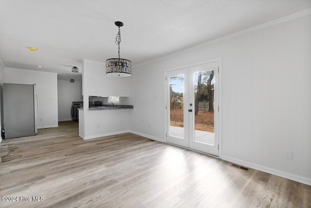 unfurnished dining area featuring french doors, sink, separate washer and dryer, light hardwood / wood-style flooring, and crown molding