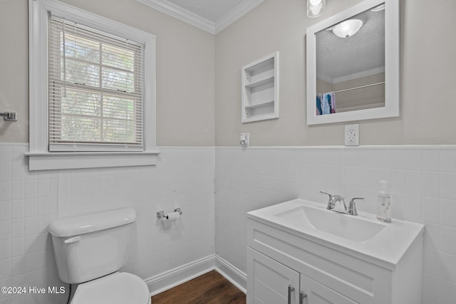 bathroom with vanity, hardwood / wood-style flooring, toilet, ornamental molding, and tile walls