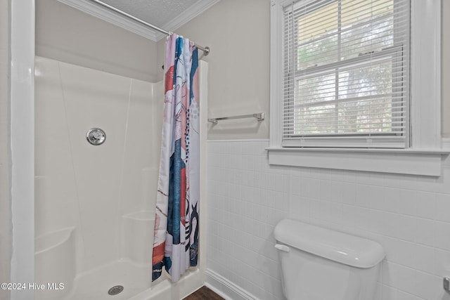 bathroom featuring toilet, curtained shower, crown molding, and tile walls