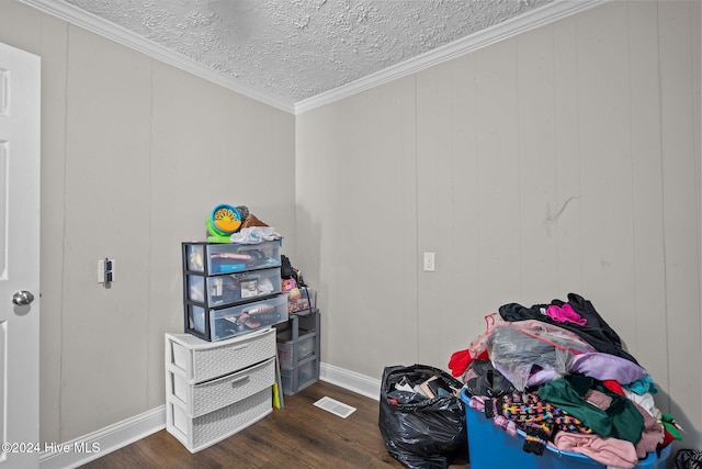 interior space featuring crown molding, wood walls, dark wood-type flooring, and a textured ceiling