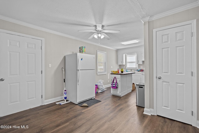 kitchen featuring white cabinetry, dark hardwood / wood-style floors, crown molding, white fridge, and a textured ceiling