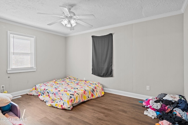 bedroom featuring hardwood / wood-style floors, a textured ceiling, ceiling fan, and ornamental molding