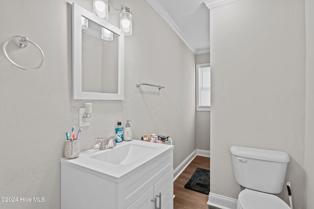 bathroom featuring vanity, toilet, wood-type flooring, and crown molding