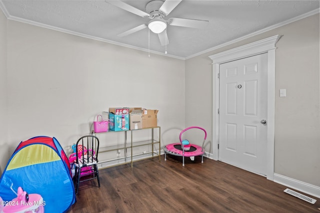 game room with dark hardwood / wood-style floors, ceiling fan, ornamental molding, and a textured ceiling