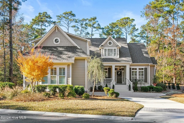 view of front of property featuring covered porch and a shingled roof