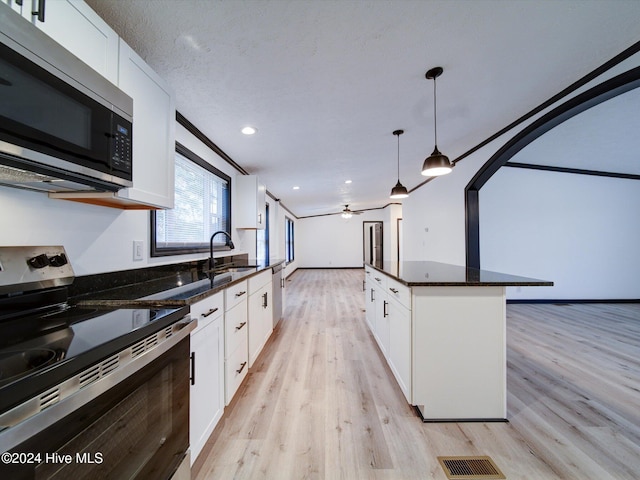 kitchen featuring ceiling fan, white cabinets, and stainless steel appliances