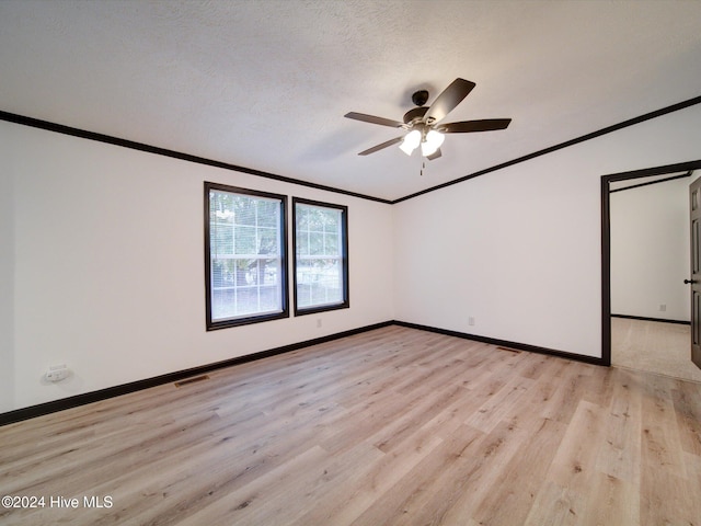 spare room with a textured ceiling, light wood-type flooring, ceiling fan, and ornamental molding