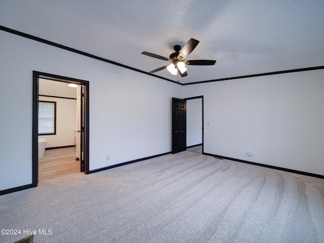 carpeted spare room with ceiling fan, a textured ceiling, and ornamental molding