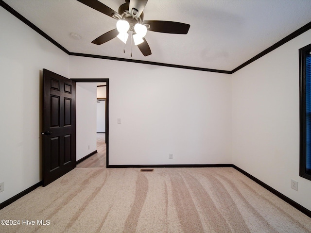 carpeted empty room with ceiling fan and ornamental molding