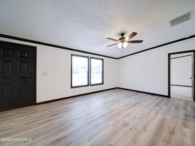 empty room with ceiling fan, ornamental molding, a textured ceiling, and light wood-type flooring