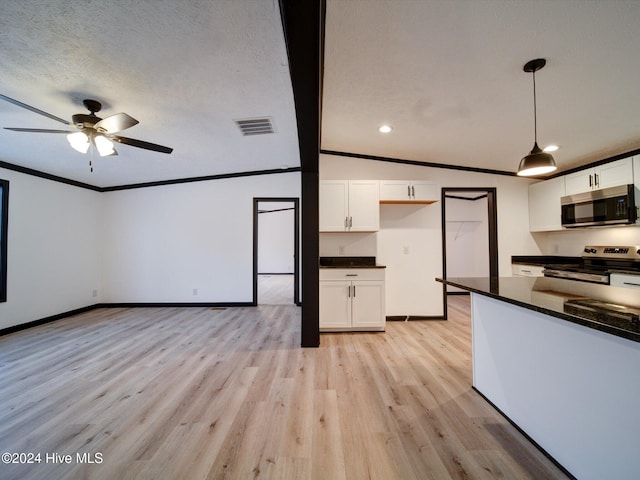 kitchen with white cabinets, light wood-type flooring, decorative light fixtures, and appliances with stainless steel finishes