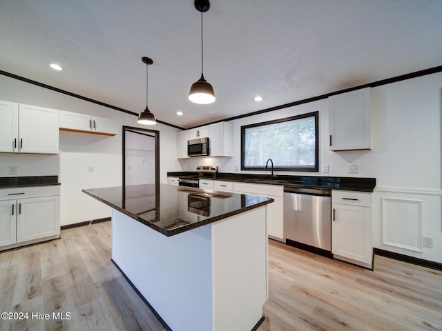 kitchen featuring white cabinets, decorative light fixtures, and stainless steel appliances