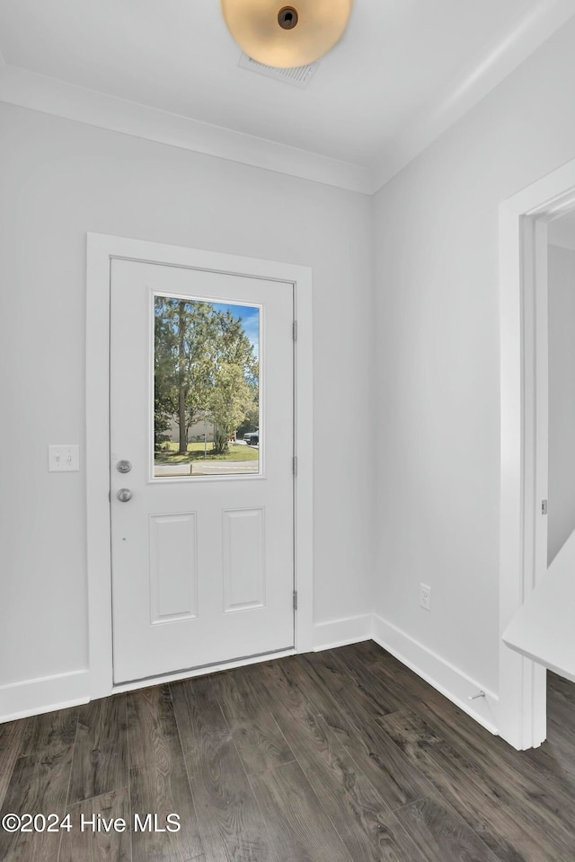 foyer entrance with crown molding and dark hardwood / wood-style floors