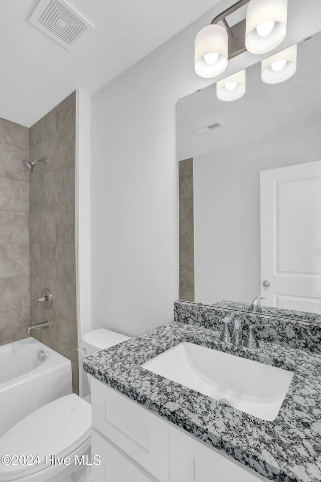 full bathroom with vanity, toilet, and tiled shower / bath