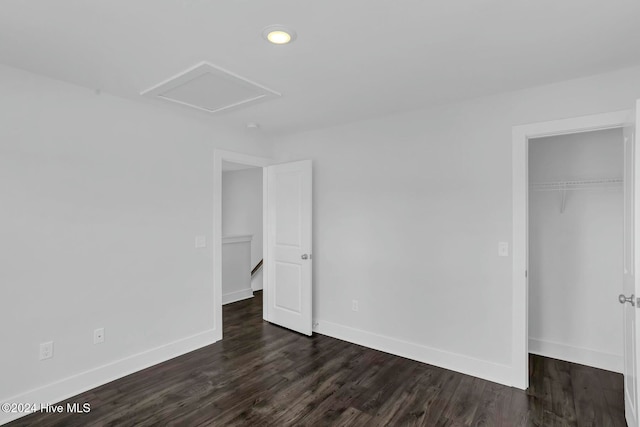 unfurnished bedroom with dark hardwood / wood-style floors and a closet