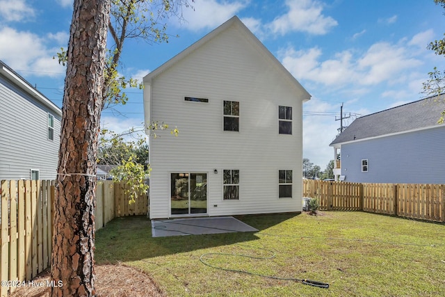 back of house with a patio area and a yard