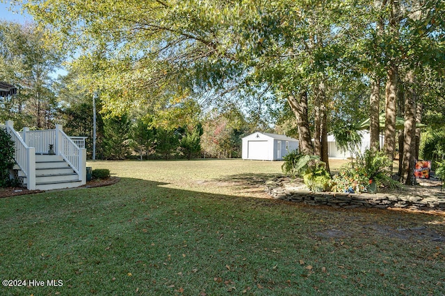 view of yard with a garage, an outdoor structure, and a wooden deck