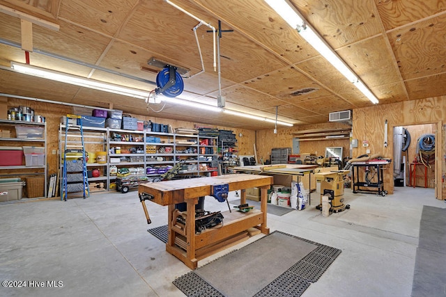 garage with a workshop area and wooden walls