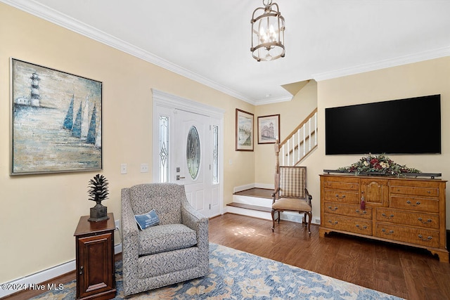 living area featuring baseboard heating, crown molding, wood-type flooring, and an inviting chandelier