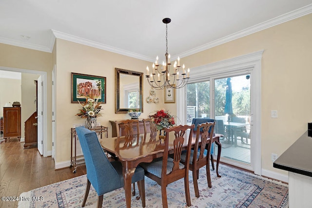 dining room with dark wood-type flooring, a notable chandelier, and ornamental molding