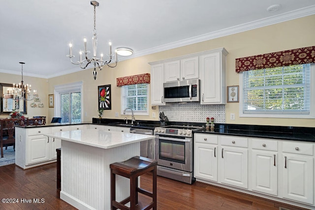 kitchen featuring dark hardwood / wood-style flooring, stainless steel appliances, a kitchen island, and a notable chandelier