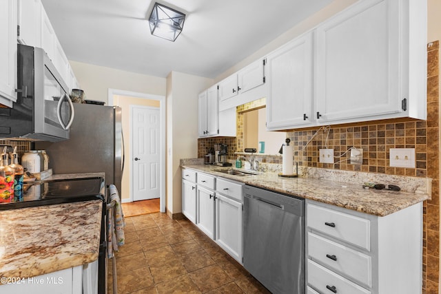 kitchen featuring light stone countertops, sink, white cabinets, and appliances with stainless steel finishes