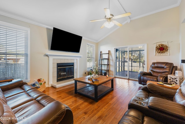 living room with a fireplace, hardwood / wood-style flooring, vaulted ceiling, and crown molding