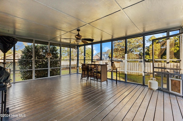 unfurnished sunroom featuring a wealth of natural light and ceiling fan