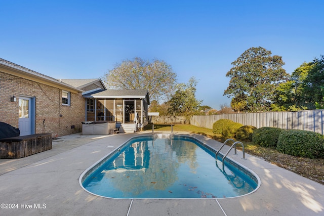 view of swimming pool with a patio area and a sunroom