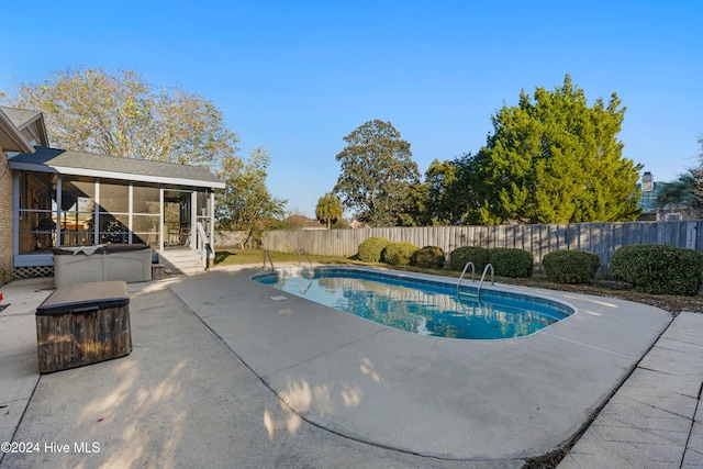 view of pool featuring a sunroom and a patio