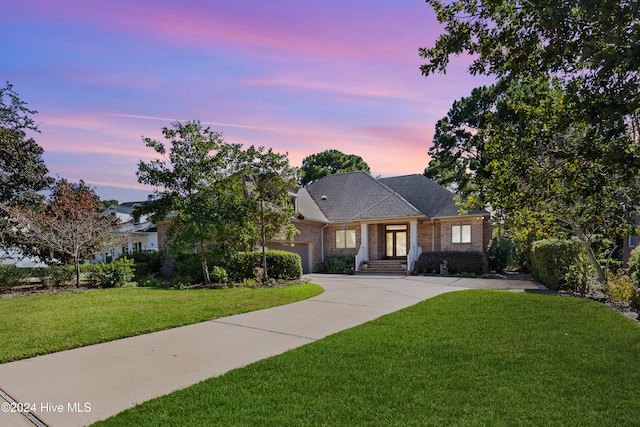 view of front of home with a garage and a yard