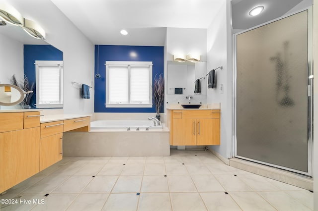 bathroom with plenty of natural light, a garden tub, a stall shower, and a sink