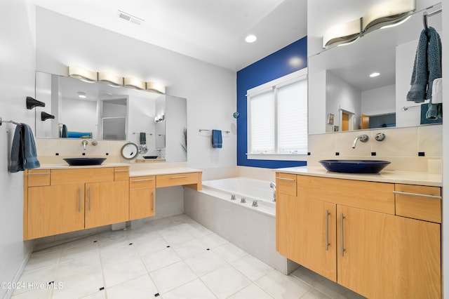 bathroom featuring tasteful backsplash, a washtub, vanity, and tile patterned flooring