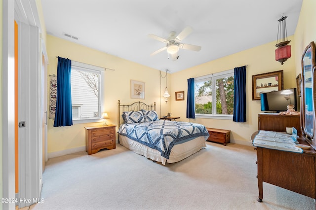 carpeted bedroom with baseboards, visible vents, and ceiling fan