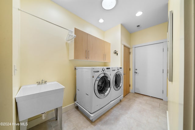 laundry area with separate washer and dryer, sink, and cabinets