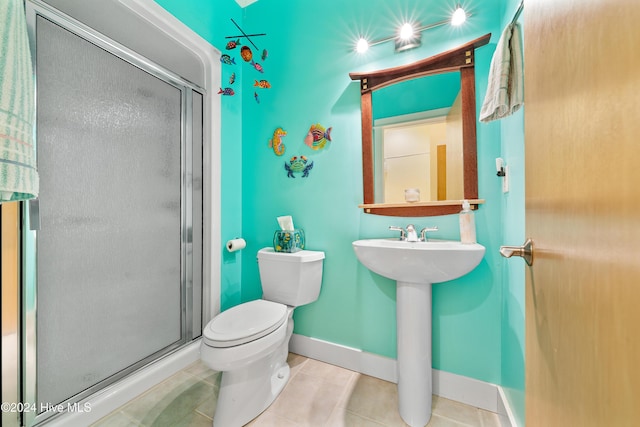 full bathroom featuring baseboards, toilet, tile patterned flooring, and a stall shower