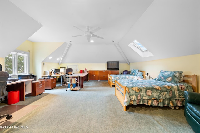 bedroom with ceiling fan, lofted ceiling with skylight, and light colored carpet