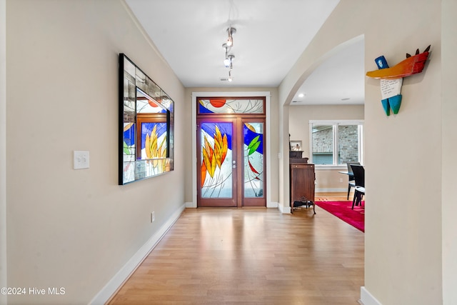 foyer entrance with french doors and light hardwood / wood-style floors