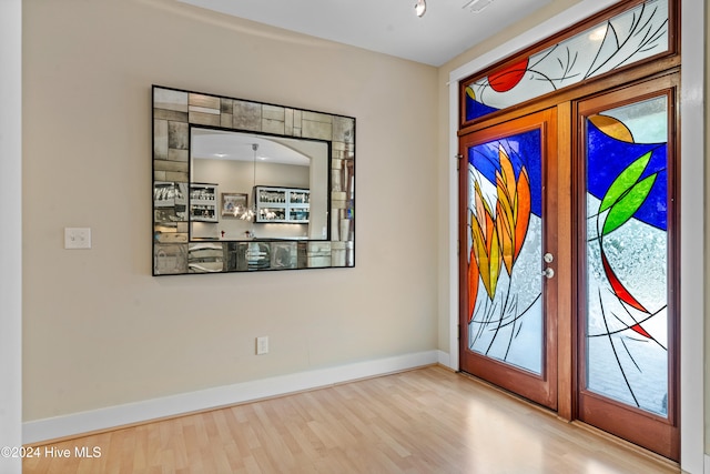 foyer entrance featuring hardwood / wood-style floors and french doors